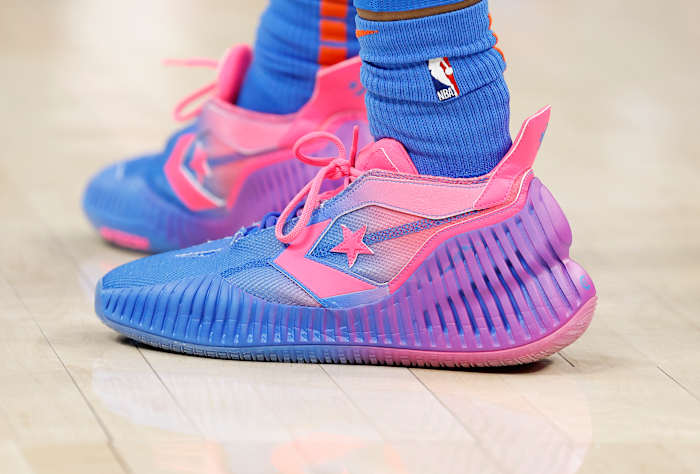 View of pink and purple Converse shoes.